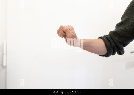 Un cliché de la main d'un homme en position de claquement de porte sur fond blanc Banque D'Images