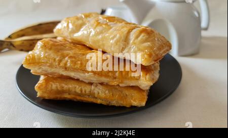 Feuilletés de plantain doux faits maison avec des plantain mûr et de stocker les feuilles de pâte feuilletées achetées. Prise de vue sur fond blanc Banque D'Images