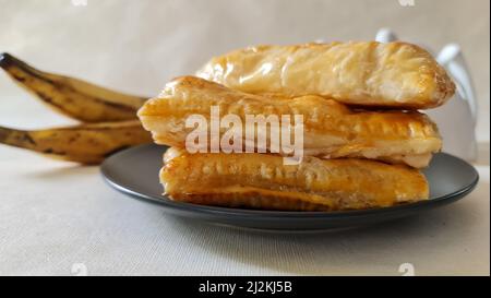 Feuilletés de plantain doux faits maison avec des plantain mûr et de stocker les feuilles de pâte feuilletées achetées. Prise de vue sur fond blanc Banque D'Images