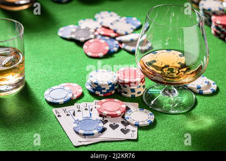 Gros plan de la table de poker avec des cartes, des jetons et des chiksy. Table de poker avec cartes, jetons et un verre de whisky avec glace. Banque D'Images
