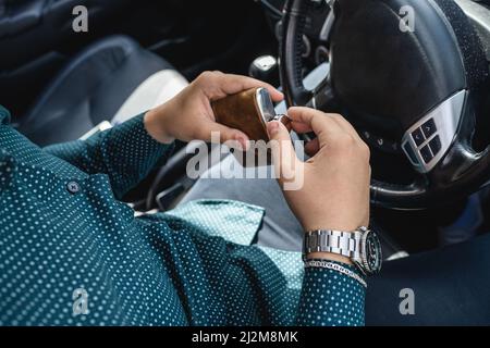 homme caucasien boire de l'alcool à la fiole tout en conduisant une voiture ivre gros plan sur l'alcoolisme de boisson et l'abus d'alcool concept ivre conducteur dangereux Banque D'Images