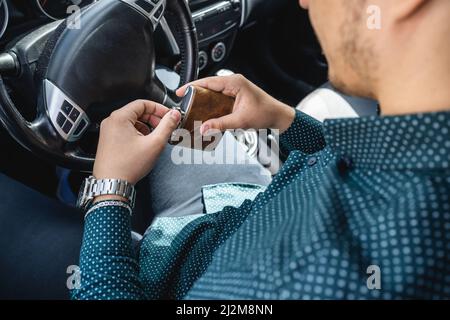 homme caucasien boire de l'alcool à la fiole tout en conduisant une voiture ivre gros plan sur l'alcoolisme de boisson et l'abus d'alcool concept ivre conducteur dangereux Banque D'Images