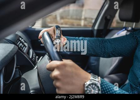 homme caucasien boire de l'alcool à la fiole tout en conduisant une voiture ivre gros plan sur l'alcoolisme de boisson et l'abus d'alcool concept ivre conducteur dangereux Banque D'Images