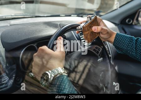 homme caucasien boire de l'alcool à la fiole tout en conduisant une voiture ivre gros plan sur l'alcoolisme de boisson et l'abus d'alcool concept ivre conducteur dangereux Banque D'Images