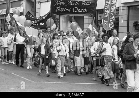 Clowns, poussettes et choeurs se sont tous avéré pour stimuler la deuxième marche annuelle pour Jésus. Des centaines de churchgoers locaux ont assisté à la marche, l'un des nombreux qui se tiennent dans tout le pays pour diffuser le message du christianisme. Le thème de la marche interconfessionnelle de cette année était le rôle de la religion dans l'éducation des enfants. Les marcheurs ont suivi un itinéraire depuis Greenhead Park, à travers le centre-ville, chantant des hymnes et distribuant des tracts. À la suite de la marche, le prédicateur Daniel Cozens parlera plus tard dans le mois à l'église méthodiste Holmfirth et à l'église Elim. 15th septembre 1990. Banque D'Images