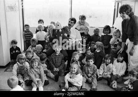 Utilisation de WElephant... L'ami soucieux de la sécurité du Service des incendies du West Yorkshire a visité le groupe de jeu Rowley Hill. La visite a été organisée par la stagiaire de CARE, clair Hannam, qui est en stage avec le groupe. Elle a organisé la visite comme projet pour le cours de la ville et des Guilds, qu'elle passe par l'entraînement en y, Lockwood. WElephant (en photo avec l'officier de la station Harry Stoyles, de Birkenshaw) a parlé aux enfants de la sécurité-incendie et des dangers de jouer avec des matchs. L'officier de station Stoyles a parlé des pompiers. 18th juin 1991. Banque D'Images