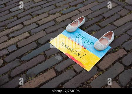 Chaussures sur un écriteau disant « Save Children, STOP Russian terrorisme! Et, ne tuez pas les enfants" pendant la manifestation "Art installation" ukrainienne. Une installation d'art par des membres de la communauté ukrainienne aux pays-Bas a été installée pour attirer l'attention, en particulier sur le gouvernement. L'installation avait des chaussures disposées en rangées dans la plaine de Het (Plain Square) dans le centre-ville de la Haye, pour attirer l'attention sur le massacre aveugle de civils et d'enfants en Ukraine, alors que l'invasion russe de l'Ukraine entrait dans les sixième semaines. (Photo de Charles M Vella/SOPA Images/Sipa USA) Banque D'Images