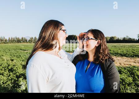 Mère et fille embrassant au milieu du champ un après-midi ensoleillé. Portrait de famille. Banque D'Images