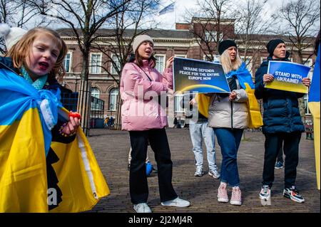 La Haye, pays-Bas. 02nd avril 2022. Le peuple ukrainien cria des slogans contre Poutine tout en tenant des pancartes pendant la manifestation. Une installation artistique ukrainienne a été placée devant la Chambre des représentants des pays-Bas, pour attirer l'attention des autorités néerlandaises et de la population sur les meurtres de civils et en particulier d'enfants pendant la guerre en Ukraine. Crédit : SOPA Images Limited/Alamy Live News Banque D'Images