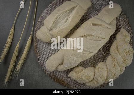 Pain de levain fermentant, fond gris avec fleur de blé séchée Banque D'Images