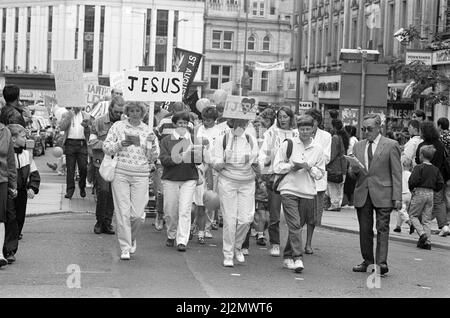 Clowns, poussettes et choeurs se sont tous avéré pour stimuler la deuxième marche annuelle pour Jésus. Des centaines de churchgoers locaux ont assisté à la marche, l'un des nombreux qui se tiennent dans tout le pays pour diffuser le message du christianisme. Le thème de la marche interconfessionnelle de cette année était le rôle de la religion dans l'éducation des enfants. Les marcheurs ont suivi un itinéraire depuis Greenhead Park, à travers le centre-ville, chantant des hymnes et distribuant des tracts. À la suite de la marche, le prédicateur Daniel Cozens parlera plus tard dans le mois à l'église méthodiste Holmfirth et à l'église Elim. 15th septembre 1990. Banque D'Images