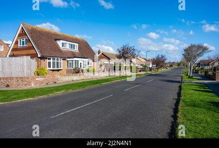 Longue route résidentielle droite ou rue sans voitures d'autres véhicules garés à Rustinington, West Sussex, Angleterre, Royaume-Uni. Route vide sans voiture. Banque D'Images