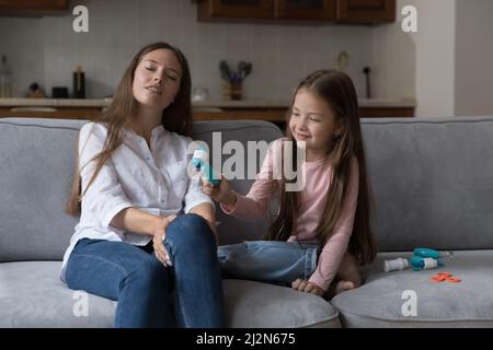 Fille curieuse et maman aimante jouant docteur et patient Banque D'Images