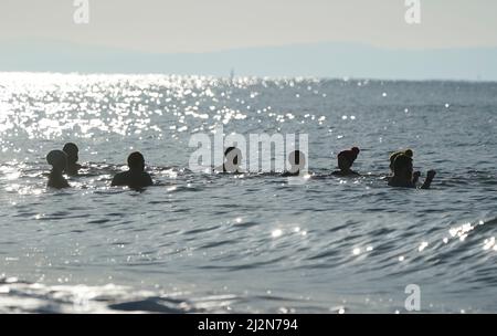 Les gens nagent dans la mer au large de la plage de Boscombe à Dorset. Date de la photo: Dimanche 3 avril 2022.