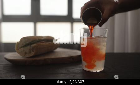 verser le sirop d'orange dans la limonade dans le verre à verre droit, photo large Banque D'Images