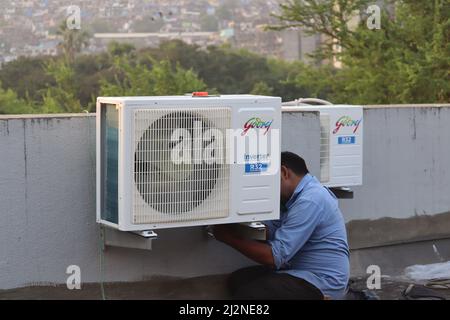 Mumbai, Maharashtra, Inde, mars 16 2022 : les conditions de l'air sont en demande à mesure que la chaleur estivale commence à augmenter. Mécanicien installant l'air du convertisseur Godrej Banque D'Images