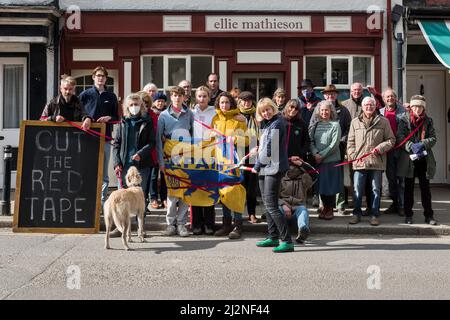 Une manifestation en faveur des réfugiés ukrainiens dans la petite ville galloise de Presteigne, Powys, Royaume-Uni, le 2/4/22. Ellie Mathieson, couturière ukrainienne (brandissant les ciseaux rouges) et Louisa Collings (en jaune), toutes deux de Presteigne, pressent le Home Office de couper la paperasserie sur les demandes de visa de réfugié. La famille Louisa sponsorise avec l’aide d’Ellie attend depuis deux semaines à Varsovie, au cours desquelles le garçon de 12 ans est tombé malade et a fini à l’hôpital sur un goutte-à-goutte. « Cette limbe que nous leur infligons ne fait qu’ajouter à leur traumatisme », explique Louisa Banque D'Images