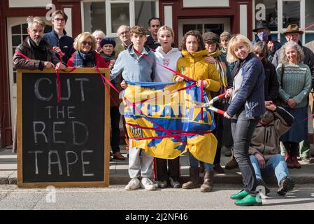 Une manifestation en faveur des réfugiés ukrainiens dans la petite ville galloise de Presteigne, Powys, Royaume-Uni, le 2/4/22. Ellie Mathieson, couturière ukrainienne (brandissant les ciseaux rouges) et Louisa Collings (en jaune), toutes deux de Presteigne, pressent le Home Office de couper la paperasserie sur les demandes de visa de réfugié. La famille Louisa sponsorise avec l’aide d’Ellie attend depuis deux semaines à Varsovie, au cours desquelles le garçon de 12 ans est tombé malade et a fini à l’hôpital sur un goutte-à-goutte. « Cette limbe que nous leur infligons ne fait qu’ajouter à leur traumatisme », explique Louisa Banque D'Images