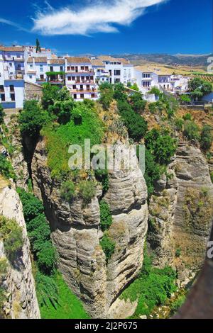 Vue sur l'ancien village Ronda situé precarily près du bord de la falaise abrupte, ciel bleu clair avec le nuage duveteux - Andalousie, Espagne Banque D'Images