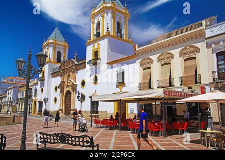 Ronda (plaza del socorro), Espagne - Mai 9. 2019: Vue sur la place avec café extérieur bar-restaurant sur l'église blanche médiévale avec 2 clochers, bleu sk Banque D'Images