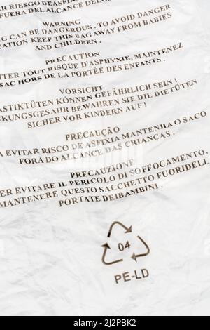 Danger de suffocation avertissement (multilingue) sur le sac LDPE / polyéthylène basse densité. Pour la sécurité des enfants, symbole Mobius de recyclage du plastique. Banque D'Images