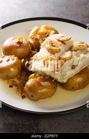 Portugais traditionnel Bacalhau un Lagareiro four Codfish cuit avec pommes de terre ferme dans l'assiette sur la table. Verticale Banque D'Images