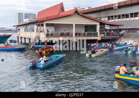 Kota Kinabalu, Malaisie - 23 mars 2019 : les bateaux à moteur avec passagers sont près du marché aux poissons KK par temps ensoleillé, transports en commun bon marché entre islan Banque D'Images