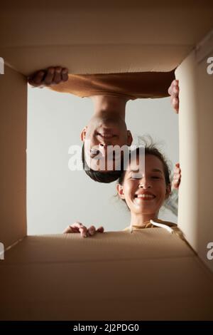 Jeune homme souriant et femme regardant à l'intérieur livré boîte avec commande Banque D'Images
