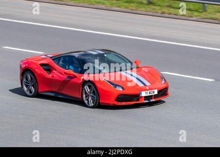 2016 rouge Ferrari 488 GTB 3902cc essence 7 vitesses semi-automatique ; conduite sur l'autoroute M61, Manchester, Royaume-Uni Banque D'Images