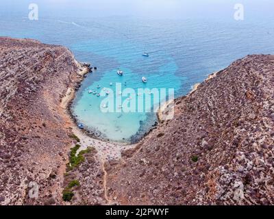 Drone aérien, Cala Pulcino à Lampedusa, crique tranquille avec paysage accidenté, eaux claires, connu sous le nom de 'caletta barche volanti' ou 'bateau volante crique' Banque D'Images