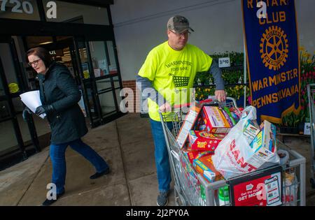 Warminster, États-Unis. 03rd avril 2022. Brian Foedisch (à droite) sort de Giant Food avec un chariot complet qui lui est remis par un client car le croiseur de police est presque rempli de sa quatrième charge lors d'une campagne alimentaire pour aider à reconstituer les étagères alimentaires de Warminster Food Bank dimanche, 03 avril, 2022 au géant de Warminster, Pennsylvanie. Plus de 2300 livres de nourriture ont été donnés avec des cartes-cadeaux et d'autres articles. (Photo par Credit: William Thomas Cain/Alay Live News Banque D'Images