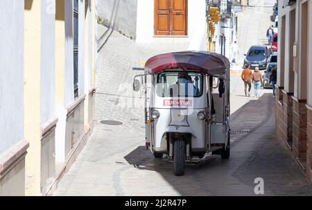 Un pousse-pousse automatique Tuk-Tuk descend les rues étroites de Setenil de las Bodegas Banque D'Images