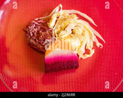 Une terrine colorée de betterave, de carotte et de chou-fleur sert une salade de radicchio et de cône de sucre. Banque D'Images