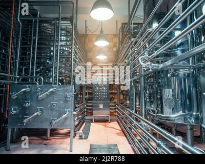 Réservoirs à bière avec beaucoup de tuyaux en acier dans la brasserie artisanale. Banque D'Images