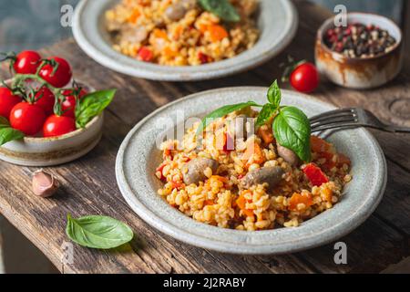 bulgur avec coeurs de poulet et légumes. Délicieux plat sain sur fond sombre. Pilaf bulgur Banque D'Images