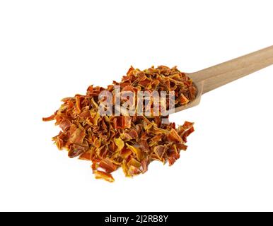 morceaux de carottes séchés sur une cuillère en bois isolée sur fond blanc. Épices et ingrédients alimentaires. Banque D'Images