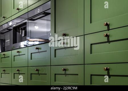 Grande armoire de cuisine verte avec de nombreuses poignées, gros plan. Banque D'Images