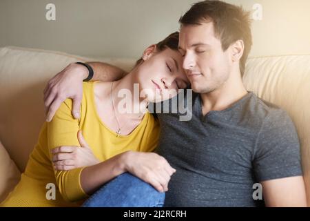 Le vrai amour signifie être là pour les uns les autres. Photo d'un couple fatigué qui se coud ensemble sur le canapé à la maison. Banque D'Images