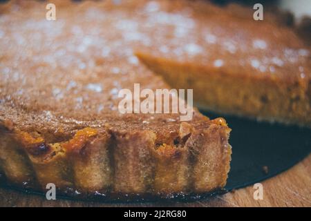 Belle tarte à la citrouille maison dorée fraîchement sortie du four et saupoudrée de sucre blanc, prête à manger. Banque D'Images