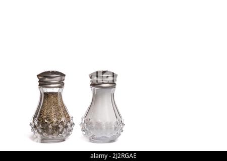 Salières et poivrières en verre avec couvercles en métal argenté sur fond blanc avec espace de copie Banque D'Images
