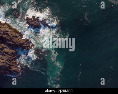 Vue aérienne. L'eau turquoise de l'océan avec des vagues blanches mousseuse bat contre la côte rocheuse. Magnifique paysage marin. Voyage en mer, loisirs, touris Banque D'Images