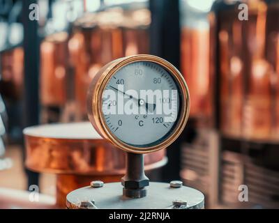 Manomètre à l'arrière-plan des réservoirs de brasserie en cuivre. Banque D'Images