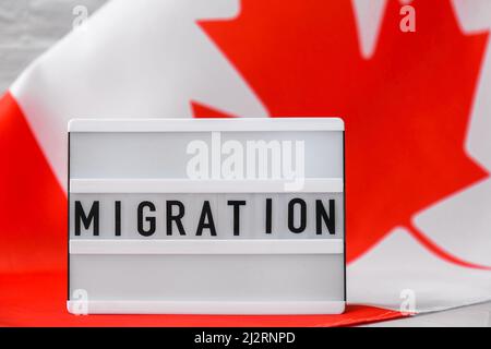 Le drapeau national du Canada. Visionneuse avec MIGRATION de texte drapeau canadien ou feuille d'érable. Patriotisme. Concept de relations internationales. Indépendance Banque D'Images