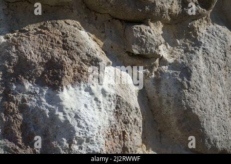 Un échantillon à effet d'efflorescence - dépôts de sel sur la maçonnerie en pierre. Vue rapprochée d'un mur de rochers dans un bâtiment historique. Le château ruine pierre co Banque D'Images