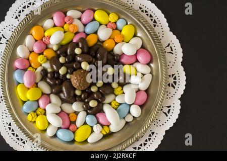 Bonbons traditionnels turcs colorés et chocolats Almond conçus dans un plateau vintage, surface noire Banque D'Images