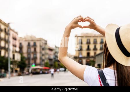 Jeune femme en forme de coeur avec les mains dans la ville de Barcelone Banque D'Images