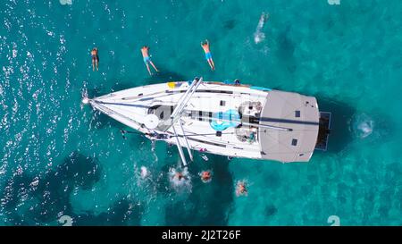 Vue de dessus de jeunes amis sautant du voilier. Yachting. Fête en bateau à voile. Excursion en bateau de luxe en été Banque D'Images