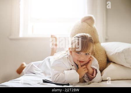 Le médecin est prêt pour vous. Photo d'une adorable petite fille vêtue comme médecin et traitant son ours en peluche comme une patiente. Banque D'Images