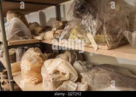 Étagères avec des paquets ou des sacs avec des morceaux d'argile faits à la main jusqu'à ce qu'ils soient tirés dans le four. Artisanat en argile et gres. Banque D'Images