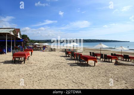 Tables et chaises d'un restaurant sur Jimbaran Beach à Bali, Indonésie. Banque D'Images